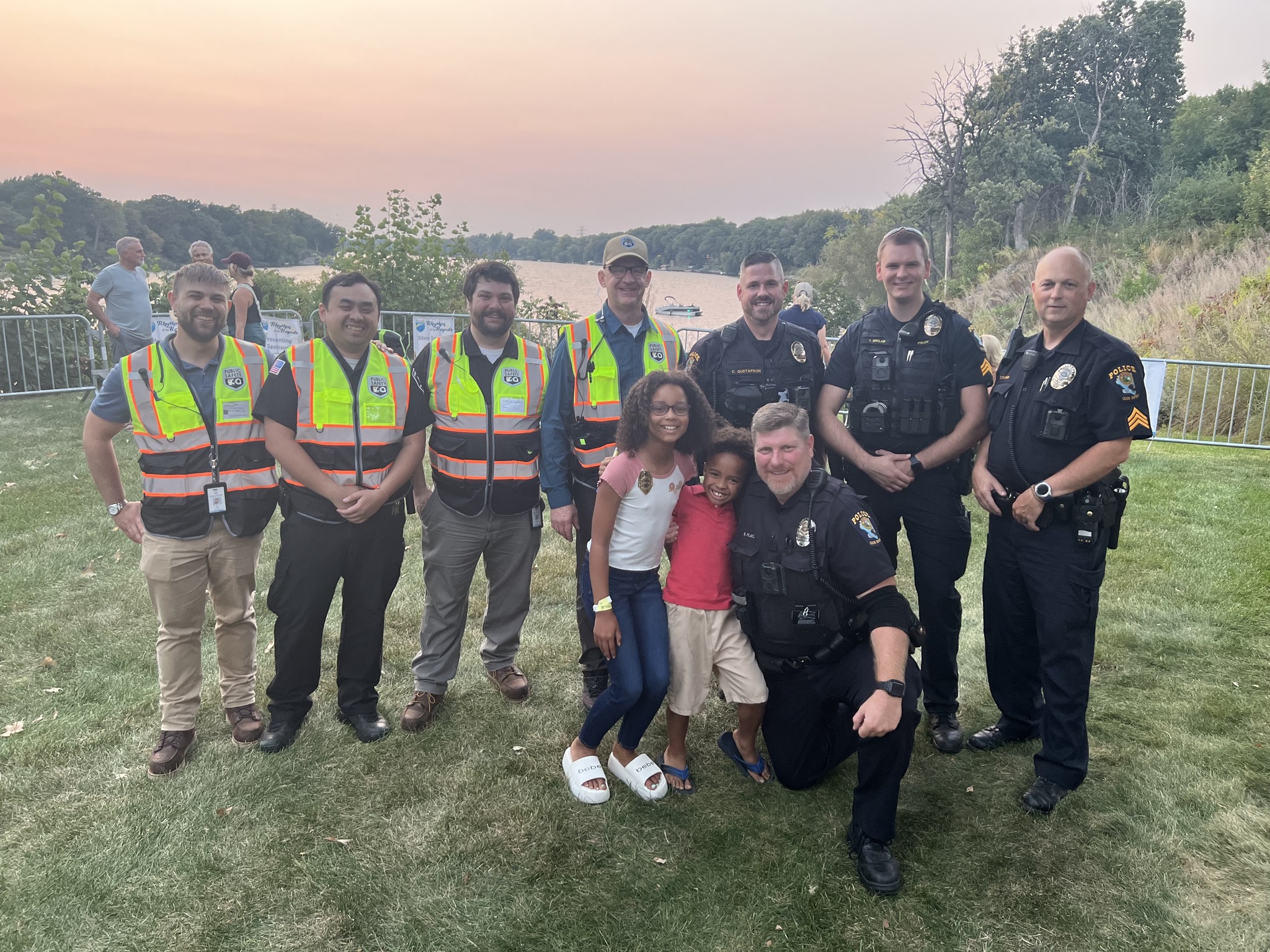 Group of Campus Security Staff and Coon Rapids Police Officers Pose with two Kids at Rhythm of the Rapids