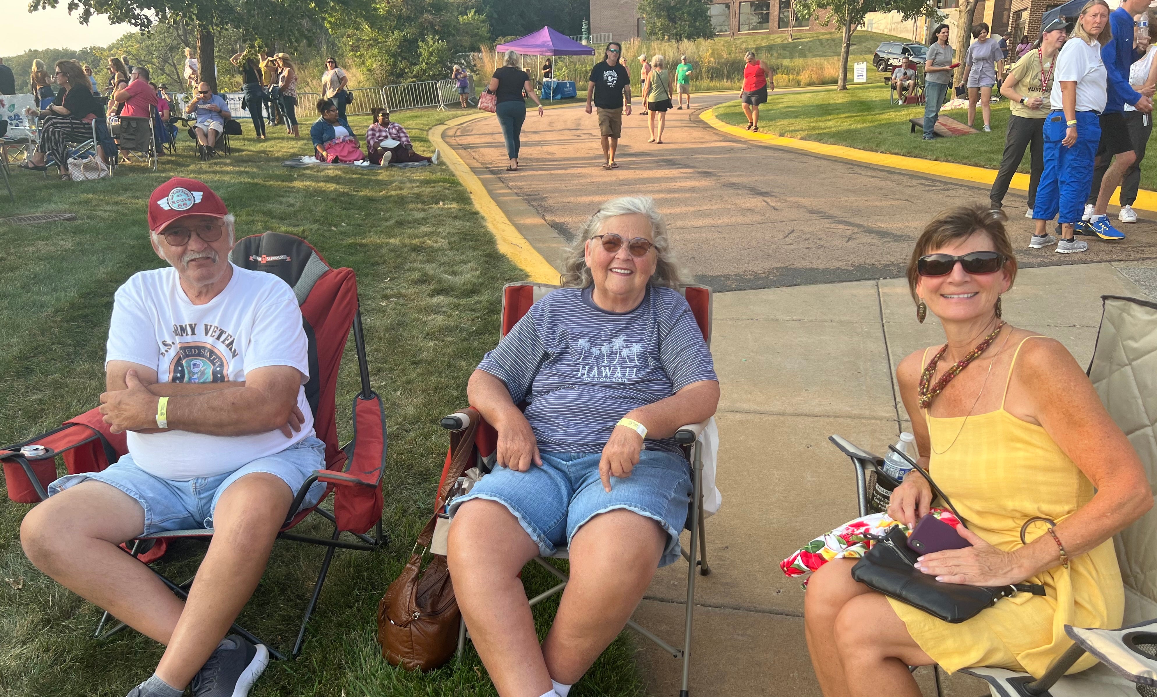 Three People Sitting in Lawn Chairs with Crowd in Background at Rhythm of the Rapids Event