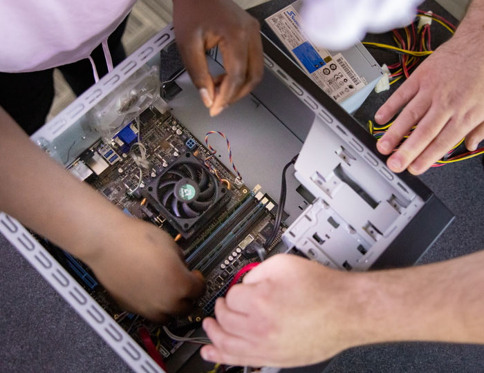 Hands working inside open desktop computer