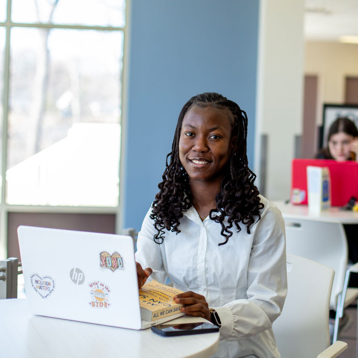 Person using a laptop at a table in a campus study space.