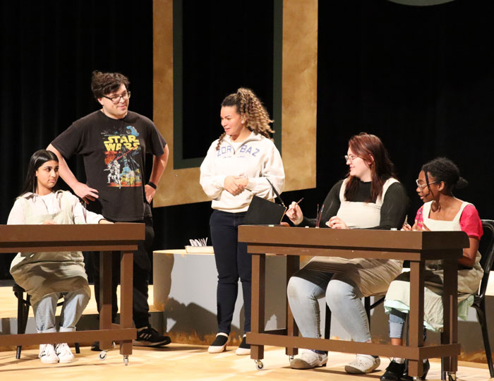 Students participating in a group rehearsal on a theater stage