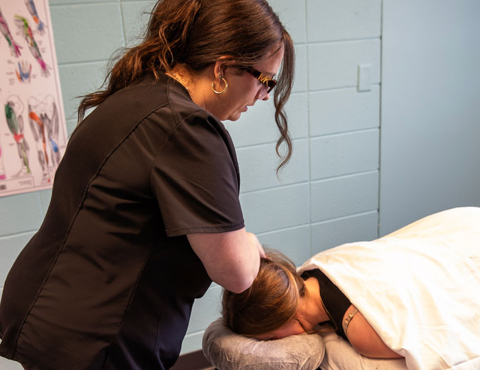 Student practicing therapeutic massage techniques in a campus lab.