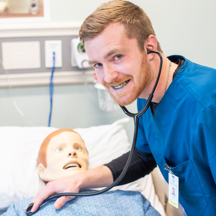Nursing student practices patient assessment on medical simulation mannequin