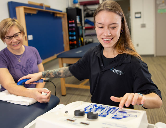 student practicing with ultrasound machine on person's arm