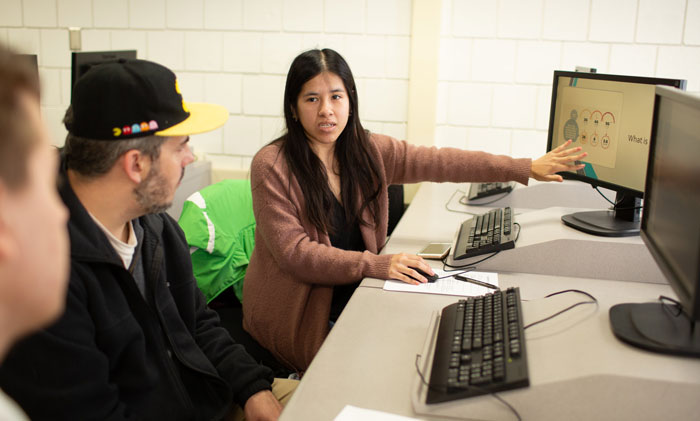 Students collaborate at desktop computers during a classroom lesson