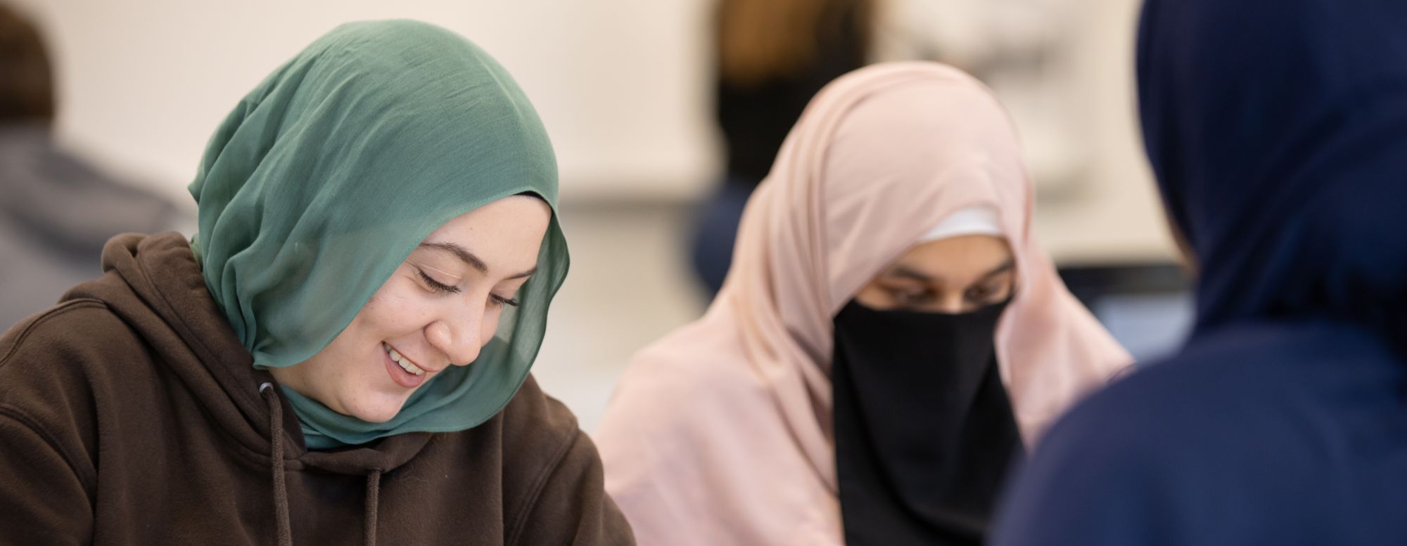 Students in headscarves study in college classroom, inclusive learning environment