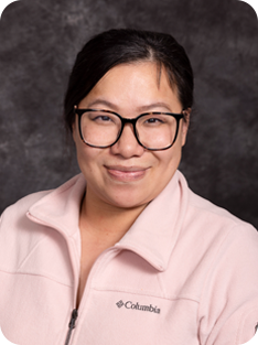 Individual wearing pink sweater and glasses