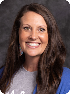 Individual wearing blue cardigan over Anoka-Ramsey t-shirt.
