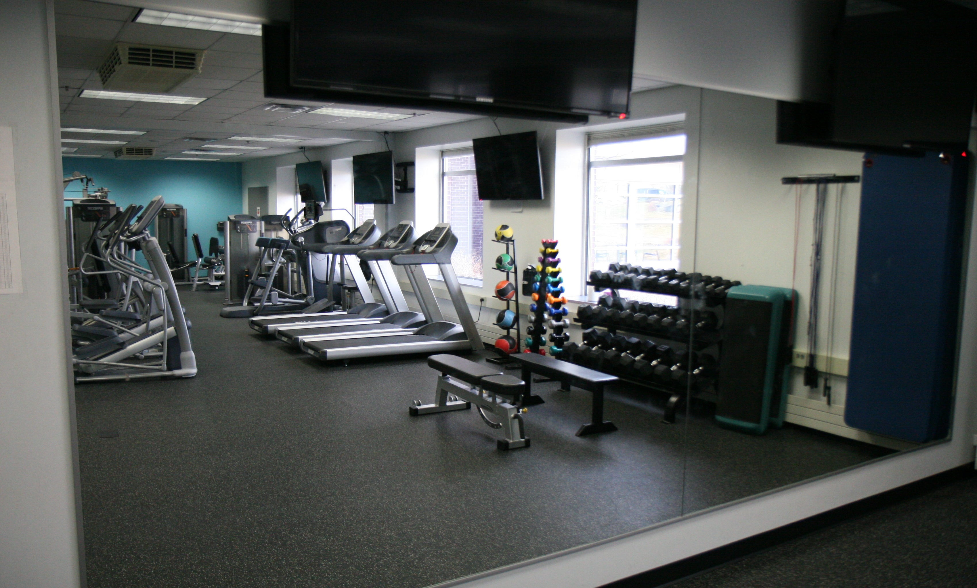 Cambridge Campus workout facilities featuring a variety workout equipment including weights, tredmills and exercise bikes.