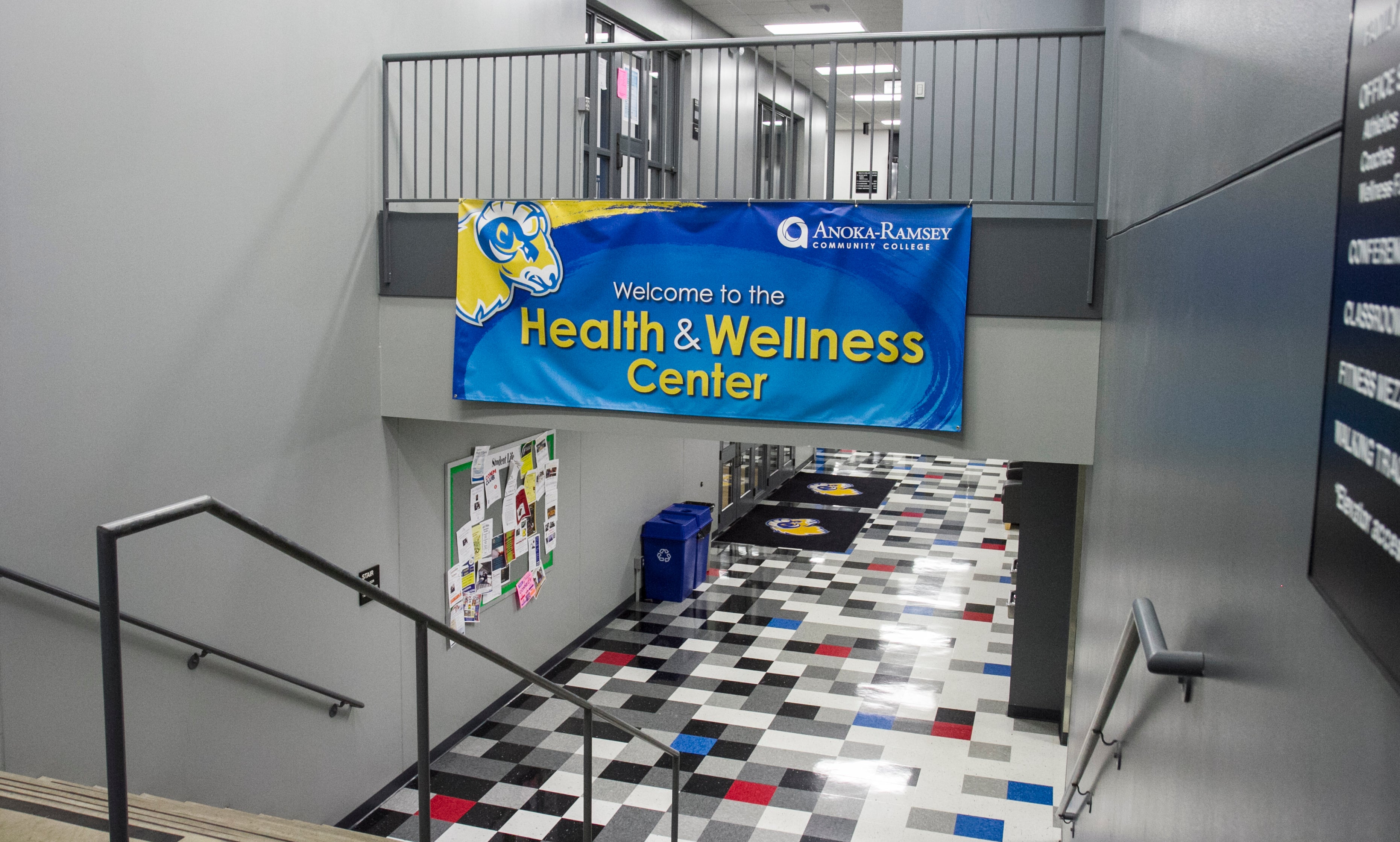 Looking down the stairs into a hallway with a banner saying "Health & Wellness Center" overhead. 